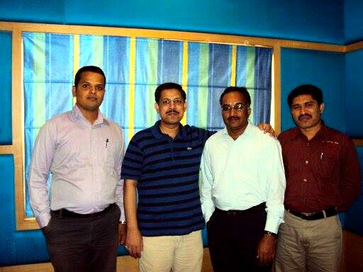 Ravi Thota with colleagues in a blue office room